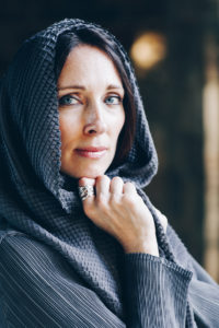 Lurainya Koerber modeling headshot photo showing blue eyes behind draping scarf wearing custom jewelry